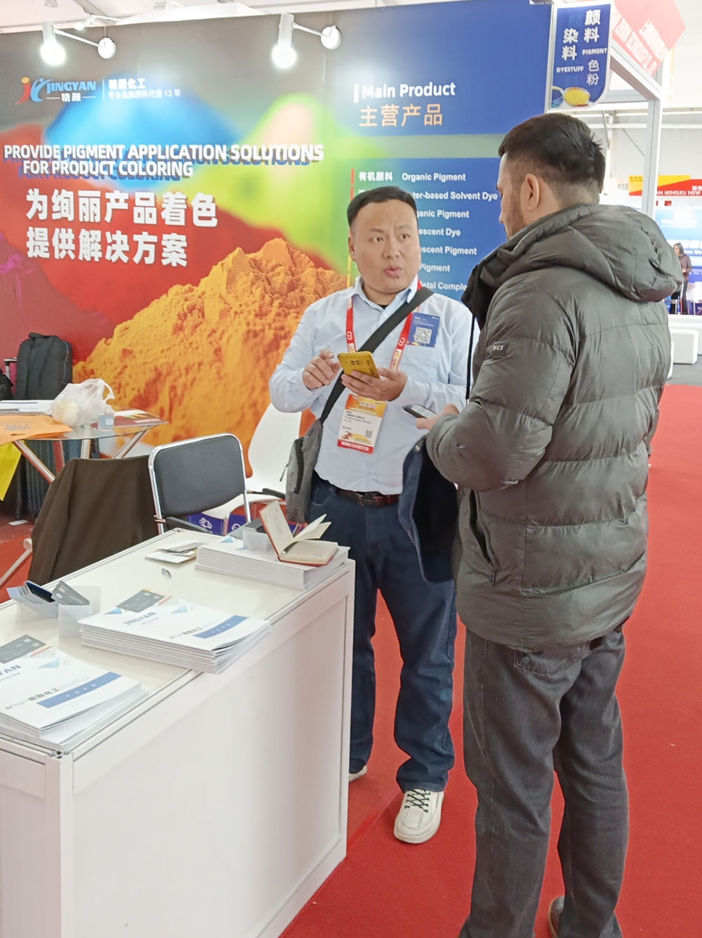 精顏化工團隊在展位與客戶交流應(yīng)用方案